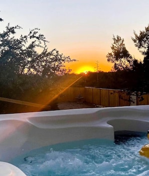 A hot tub area with a sunset in the background.
