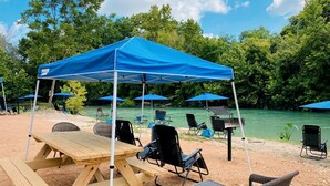 Un montaje para picnic con una mesa, sillas y un toldo azul.
