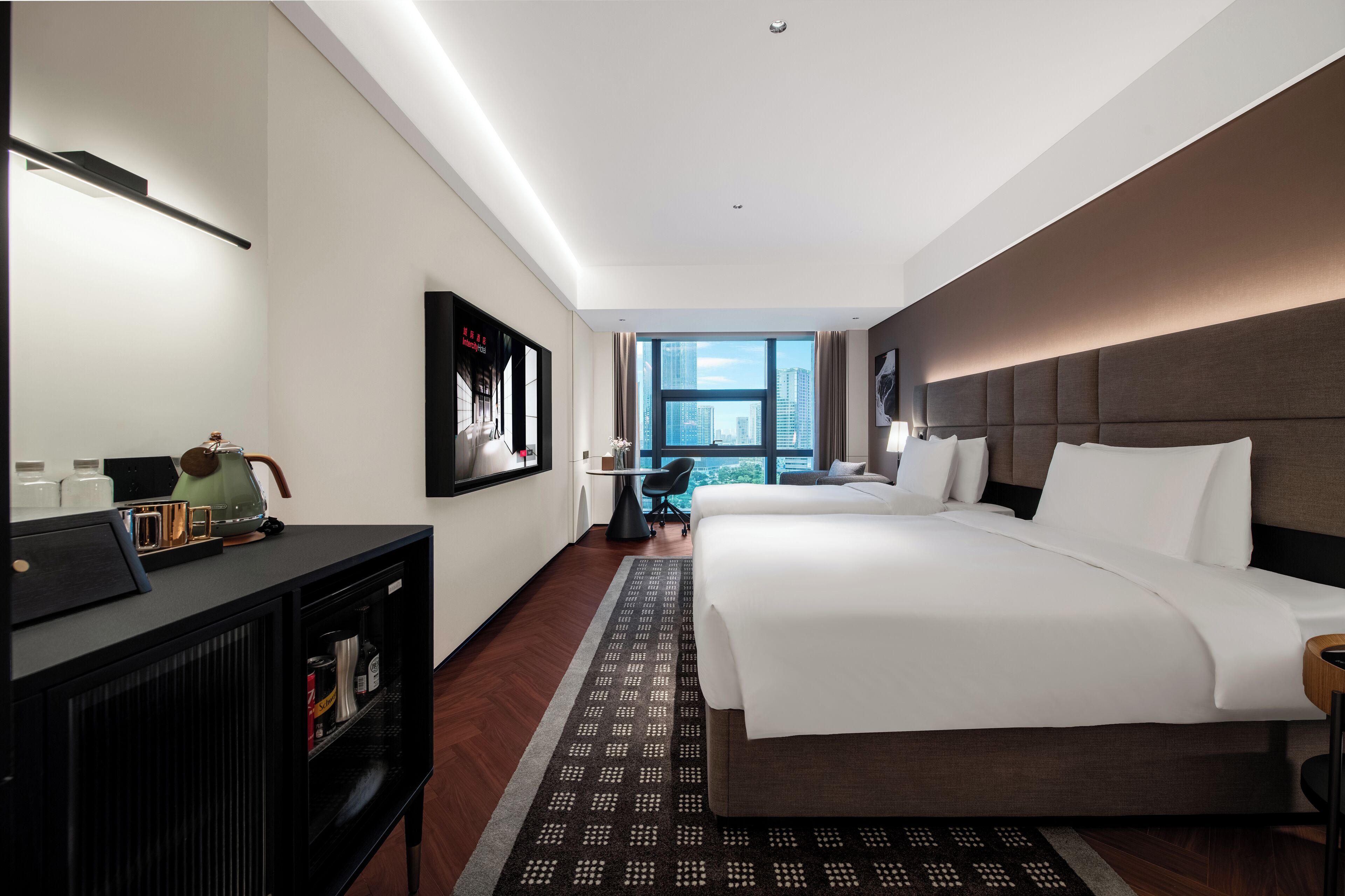 Une chambre d’hôtel avec un grand lit, un bureau, une chaise et une vue sur la ville.