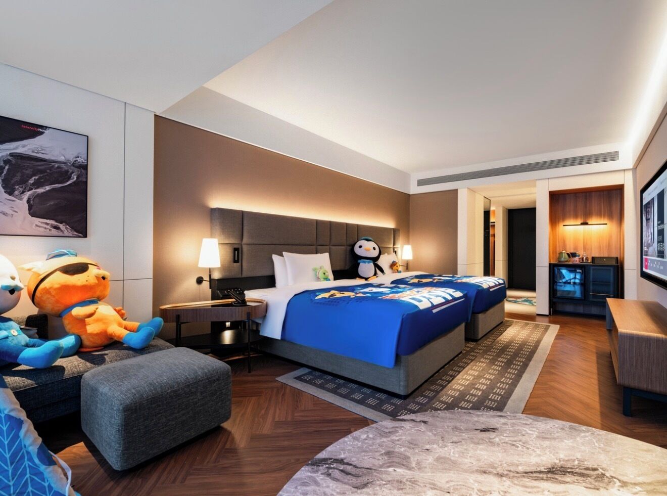 Una habitación de hotel con cama, escritorio, sillón, sofá y televisor.