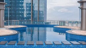 Una piscina en la azotea con vistas a edificios modernos.