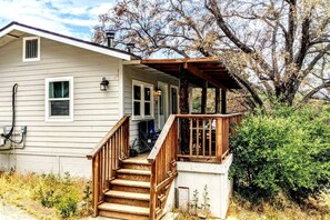 Une maison à deux étages avec un escalier en bois menant à un porche.