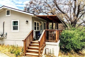 A two-story house with a wooden staircase leading to a porch. - Santa Ysabel Lakeview Glamping: Your Secluded Nature Escape (Santa Ysabel)