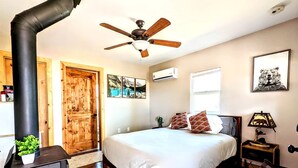 A bedroom with a bed, a ceiling fan, a heater, a window, and a door. - Santa Ysabel Lakeview Glamping: Your Secluded Nature Escape (Santa Ysabel)