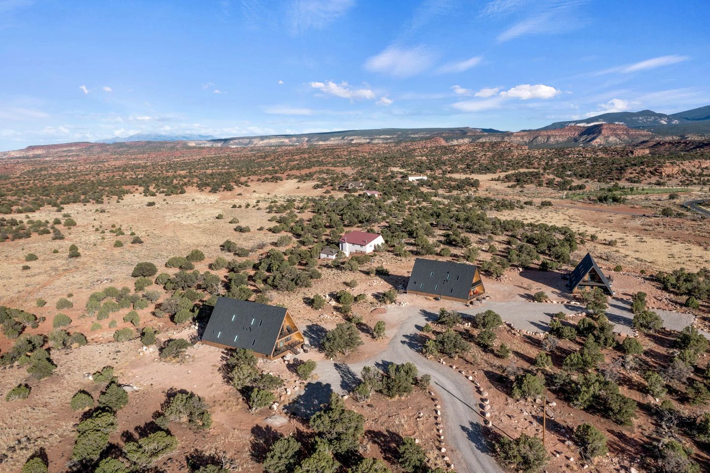 A remote, arid landscape with sparse vegetation and a few isolated buildings.