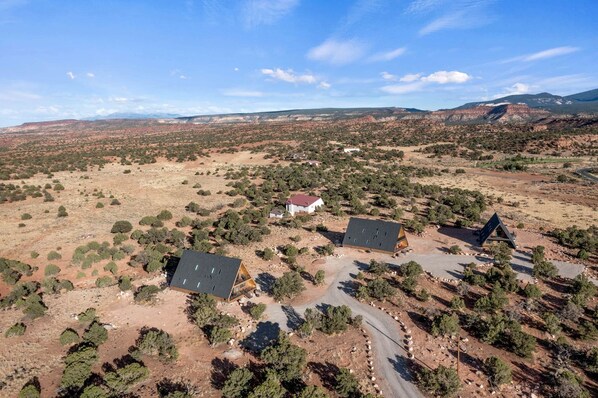 A remote, arid landscape with sparse vegetation and a few isolated buildings.