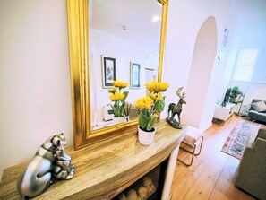 A living room with a wooden console table, a large mirror, a sofa, and a fireplace. - Sea View and Cozy Apartment (Sunderland)