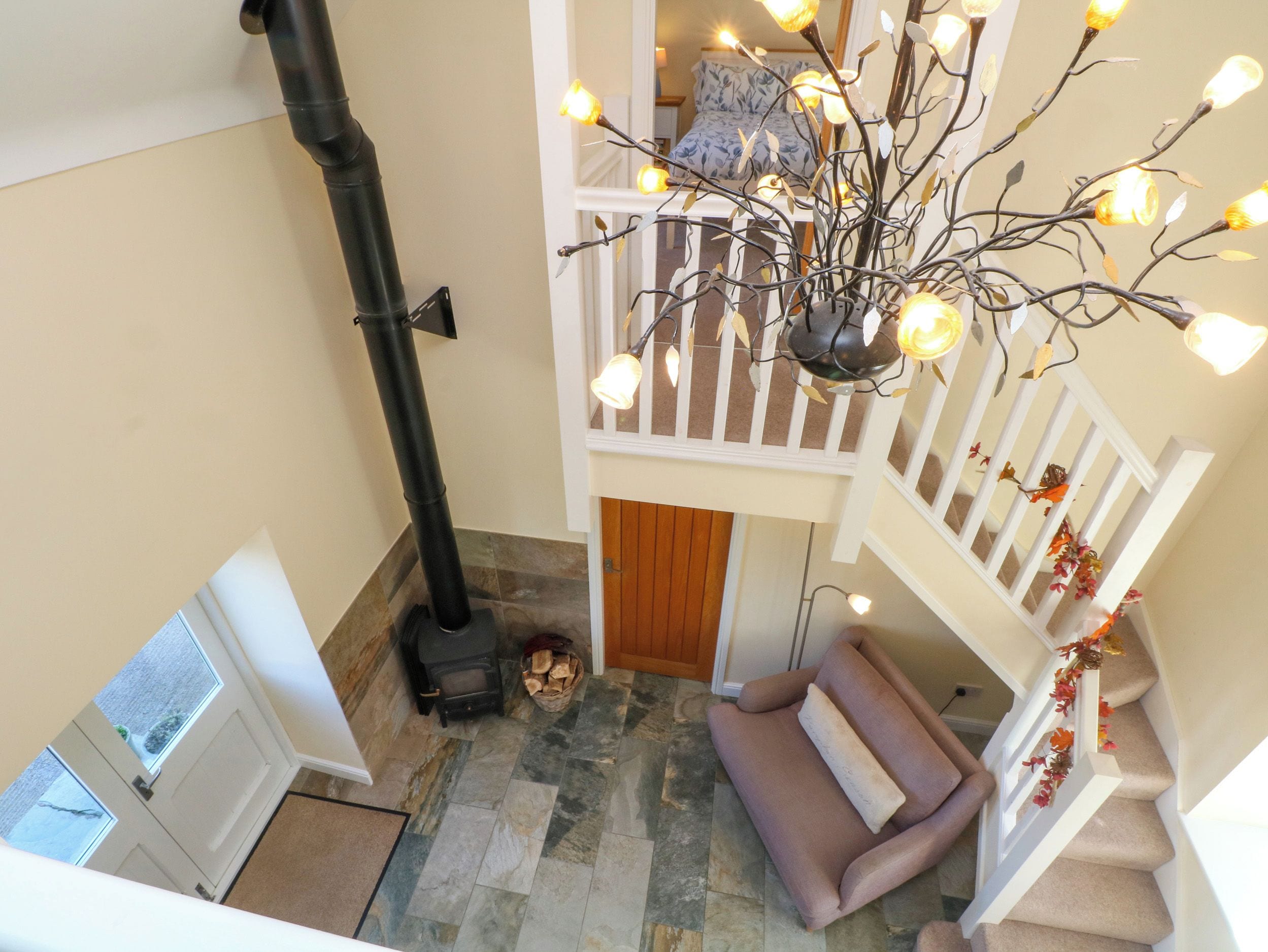 A multi-level interior with a fireplace, a staircase, and a seating area.