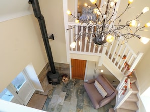 A multi-level interior with a fireplace, a staircase, and a seating area. - Plas Tirion Cottage (Holywell)
