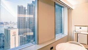 A hotel room with a large window offering a view of high-rise buildings and a river. - JI Wuhan Jianghan Road Pedestrian Street (Wuhan)