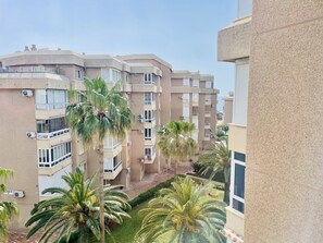 A multi-story residential building with balconies, air conditioning units, and palm trees. - Goldk Sten by At Home Costa del Sol (Torrox)