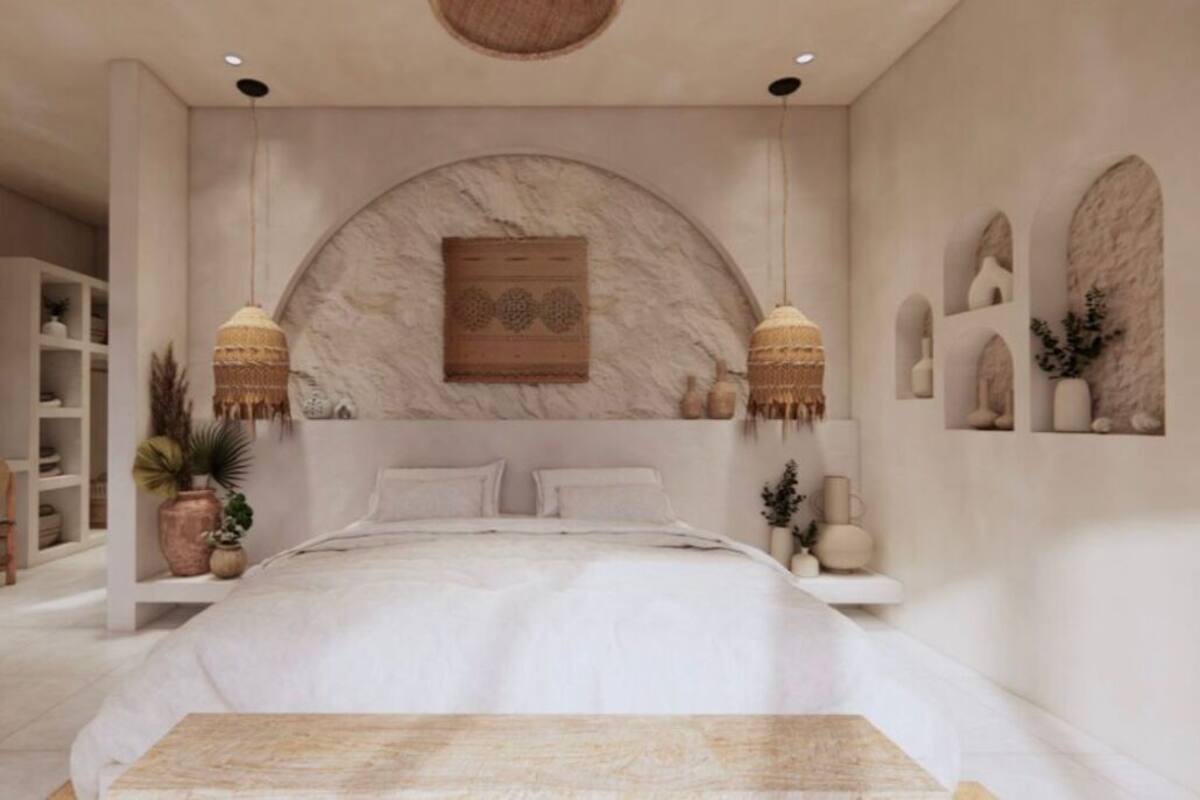 A bedroom with a large bed, two bedside tables, a wall-mounted shelf, and a hanging light fixture.