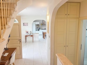 Un interno moderno con una scala, una zona cucina e uno spazio pranzo.
