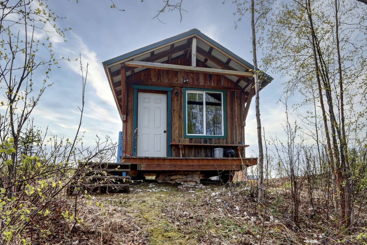 A wooden cabin with a door, window, and a small porch.