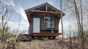 A wooden cabin with a door, window, and a small porch.