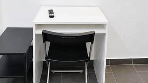 A white desk with a black chair and a small black table. - 2. Transit 2B Center-Station-Airport (Charleroi)