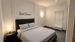 A bedroom with a bed, a nightstand, a wall-mounted shelf, and a wardrobe. - 2. Transit 2B Center-Station-Airport (Charleroi)
