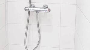 A shower with a handheld showerhead and a fixed showerhead, both mounted on a wall with white tiles. - 2. Transit 2B Center-Station-Airport (Charleroi)