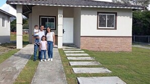 A residential house with a covered porch, a brick base, and a number '39' on the door. - Cozy Mountain View House - Ayala's House View (Volcán)