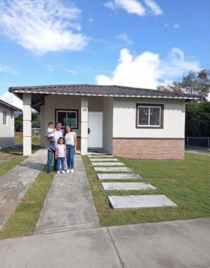 Una casa residencial con un porche cubierto, base de ladrillo y el número 39 en la puerta.
