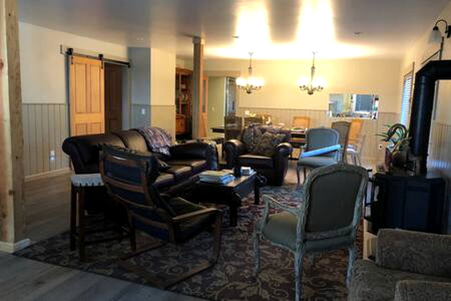 A living room with a sofa, chairs, a coffee table, and a rug.