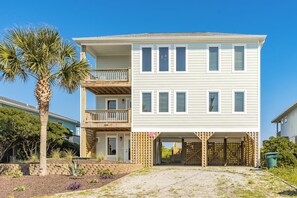 A two-story beachfront house with a balcony, a gated entrance, and a clear view of the ocean. - Seascape - 4BR, Oceanfront, Dog Friendly, Fully Renovated! (Topsail Beach)