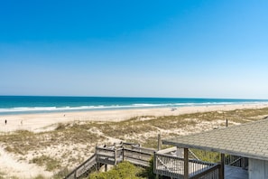 A beach view with a wooden deck and a clear sky. - Seascape - 4BR, Oceanfront, Dog Friendly, Fully Renovated! (Topsail Beach)