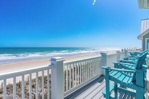 A beach view from a wooden deck with white railings and turquoise chairs. - Sea Escape - Incredible Oceanfront 8 BR Home in Gated Community (North Topsail Beach)