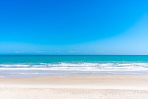 A beach with clear blue water and a sandy shore. - Sea Escape - Incredible Oceanfront 8 BR Home in Gated Community (North Topsail Beach)