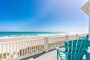 A beach view from a balcony with white railings and turquoise chairs. - Sea Escape - Incredible Oceanfront 8 Bedroom Home in Gated Community (North Topsail Beach)