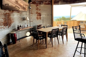 A rustic dining area with a wooden table and chairs, a lamp, and a bicycle.