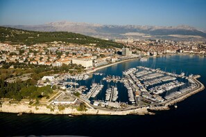 An aerial view of a coastal city with a marina, buildings, and mountains in the background. - 201 luxury attic room in the heart of Split with roof terrace (Split)