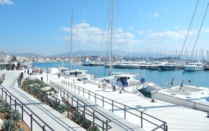 A marina with boats docked, a pedestrian walkway, and a cityscape in the background. - 201 luxury attic room in the heart of Split with roof terrace (Split)