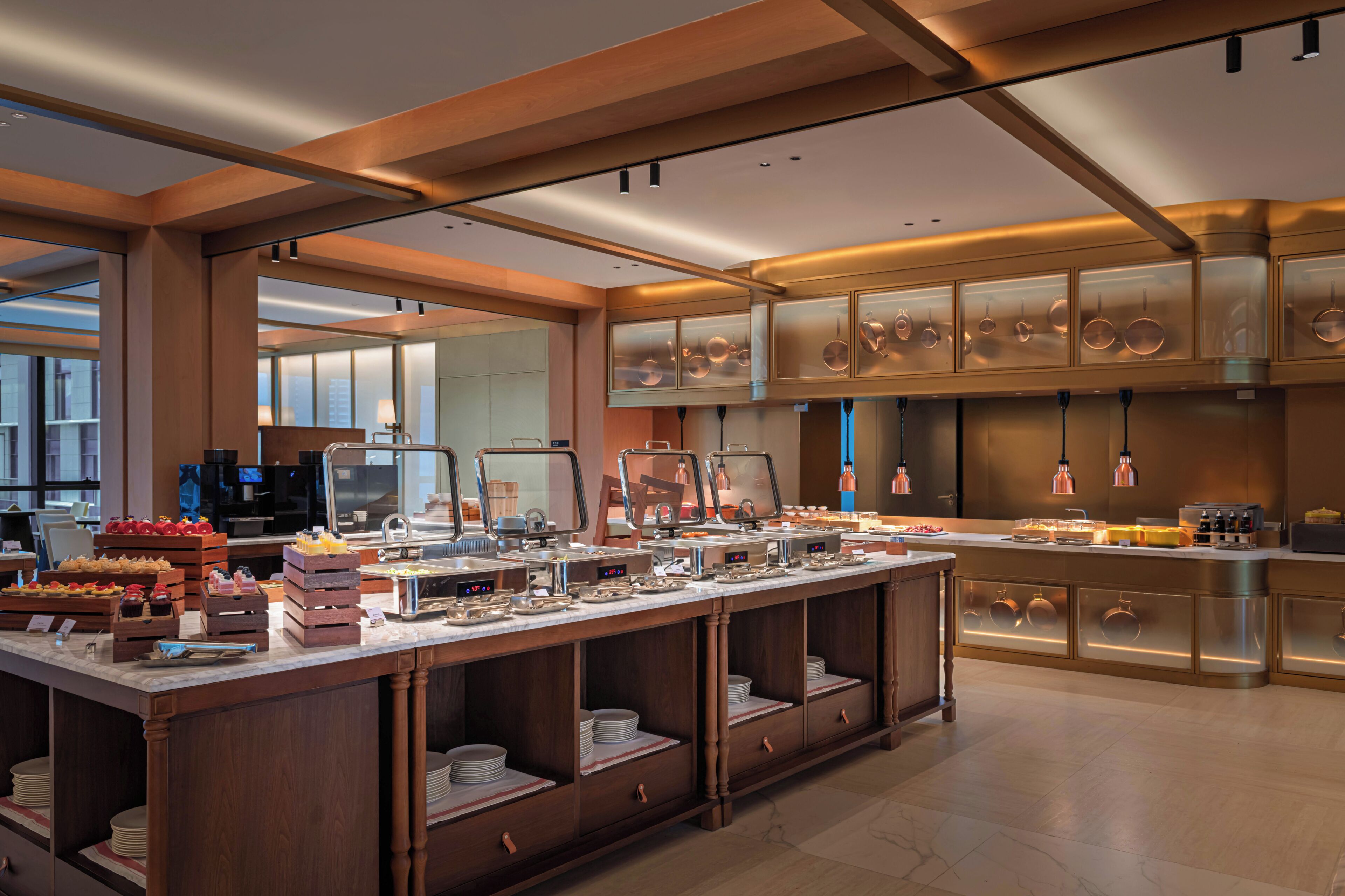 A modern kitchen with a buffet setup, including various food items and kitchen appliances.