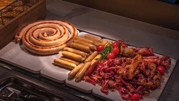 A buffet with various meats, sausages, and garnishes.