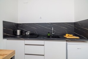 A modern kitchen with a black marble backsplash, a sink, and a compact dishwasher. - Modern studio with sea view & balcony in Crikvenica (Crikvenica)