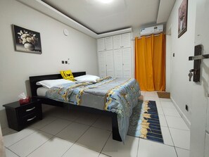 Una camera da letto con un letto, un comodino, un armadio e l'accesso al bagno.