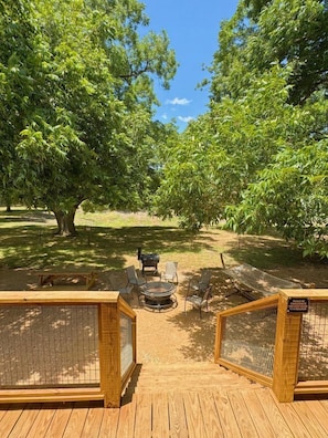 A wooden deck with a fire pit, chairs, and a picnic table.