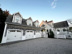 A residential building with a garage, a porch, and a staircase leading to the entrance.