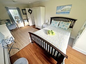 A bedroom with a bed, a desk, a chair, a wardrobe, and a window. - Beautiful Cozy Cabin in Saunderstown, Rhode Island (Jamestown)