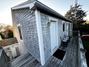 A residential building with a covered deck, a door, and a window.