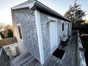 A residential building with a covered deck, a door, and a window.