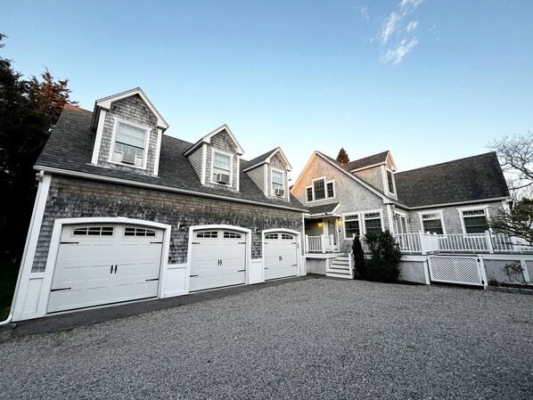 A residential building with a garage, a porch, and a staircase leading to the entrance.