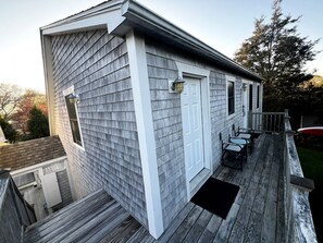 A residential building with a covered deck, a door, and a window. - Beautiful Cozy Cabin in Saunderstown, Rhode Island (Jamestown)