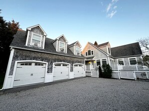 A residential building with a garage, a porch, and a staircase leading to the entrance.