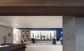 A modern interior with a kitchen area, a seating area with a sofa and chairs, and a cactus display. - WHITEBALANCE Hotel Dali (Dali)