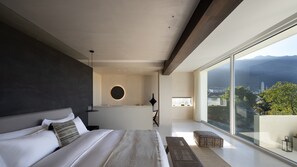 A modern bedroom with a large bed, a circular light fixture, and a view of the city through large windows. - WHITEBALANCE Hotel Dali (Dali)
