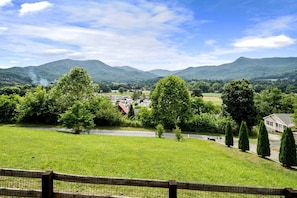 A rural landscape with a view of a small town, green fields, and mountains in the distance. - Dream Smoky Mountains Getaway: Amazing Pet-Friendly Cabin in Waynesville, North Carolina (Waynesville)
