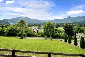 Ländliche Landschaft mit Blick auf eine kleine Stadt, grünen Feldern und Bergen in der Ferne.
