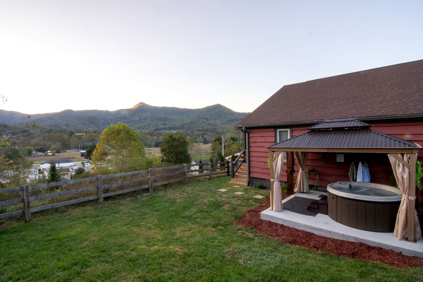 Una casa rústica con jacuzzi y un patio cubierto.